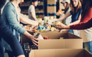 A group of unrecognizable people volunteering at a local food bank showcasing compassion generosity and community service,
