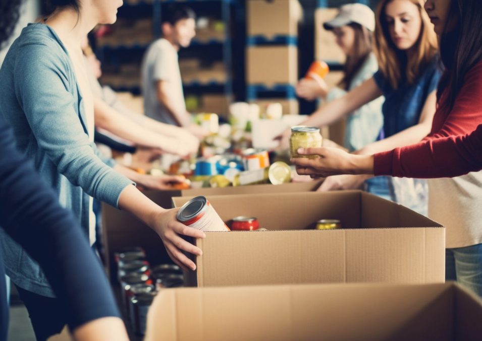 A group of unrecognizable people volunteering at a local food bank showcasing compassion generosity and community service,